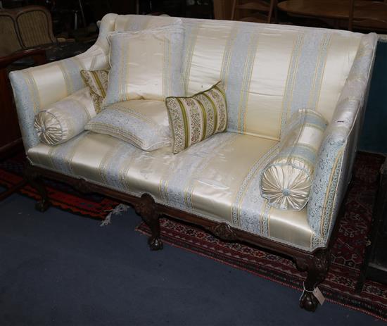A Georgian style carved mahogany settee, covered in silk, on cabriole legs, W.150cm